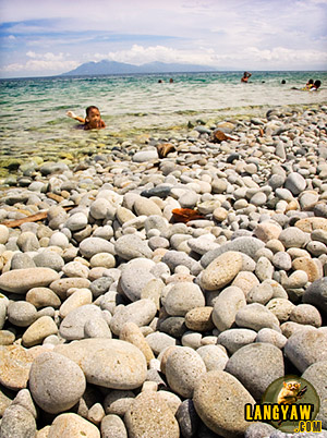 A girl bathes at the shallow waters at Mabua Pebble Beach, Surigao City. Smooth, round and flat stones provides a welcome surprise.