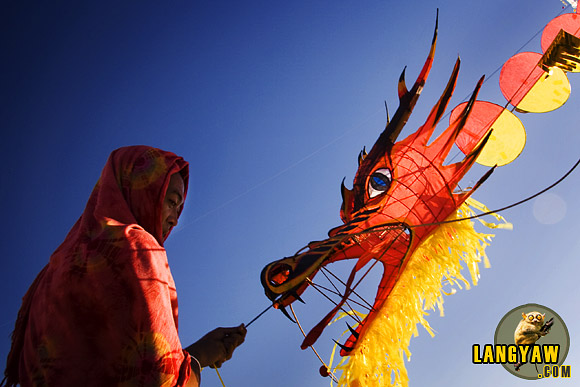 Taming the Dragon in Cebu. A kite flyer holding tightly his beast just after it flew.