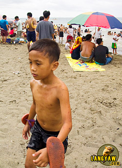 Freshly out of the water, a boy marks the end of Semana Santa at the beach in Talisay City.