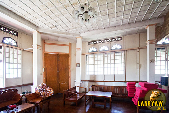 Interior of the Vargas Mansion with its coffered ceiling. Brown door opens to balcony.