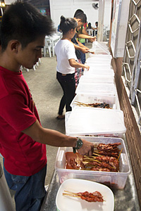 Customers choose their meat from a series of plastic containers