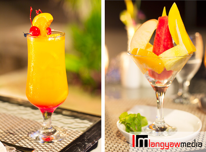 Signature sunset cocktail, left and cut fresh fruit in season with light syrup, right