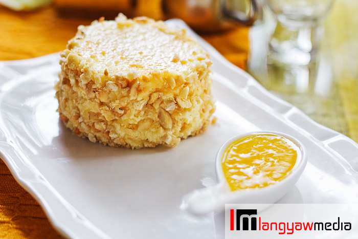 Baked cheesecake covered with peanuts and paired with fresh mango puree. It's a delightful combo!