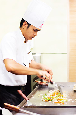 A teppanyaki chef preparing one of the dishes