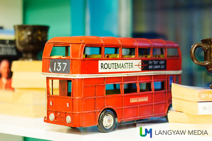 A toy double decker bus as decor in one of the shelves