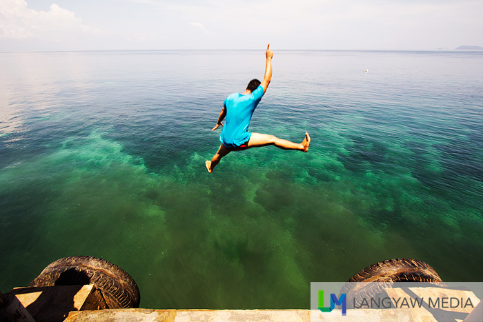 Local youth jumping from the wharf into the deep water