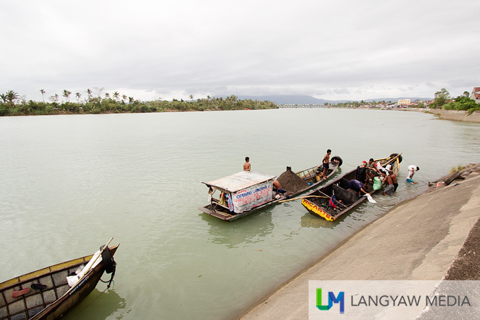 Sand quarrying boats along Libmanan's very wide river dock to unload the sand