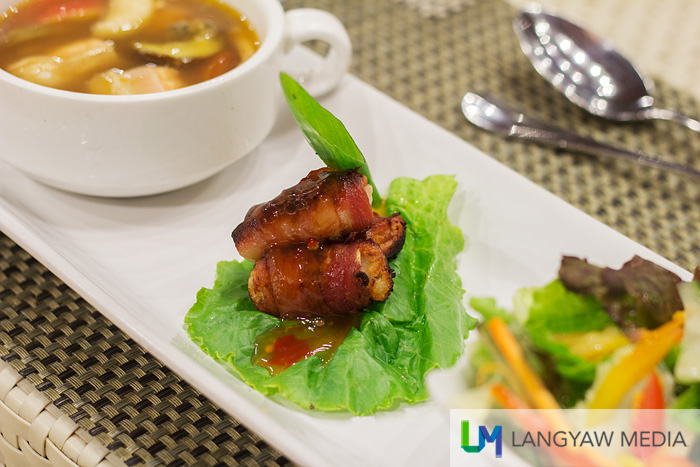 Grilled crabstick wrapped in bacon with sweet and sour sauce, salmon sinigang and salad
