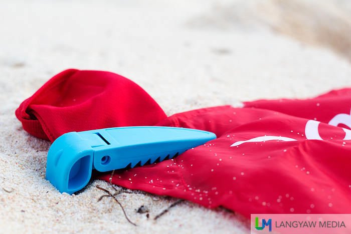 Close up of the beach blanket clip. It's teeth grips the towel to the sand.