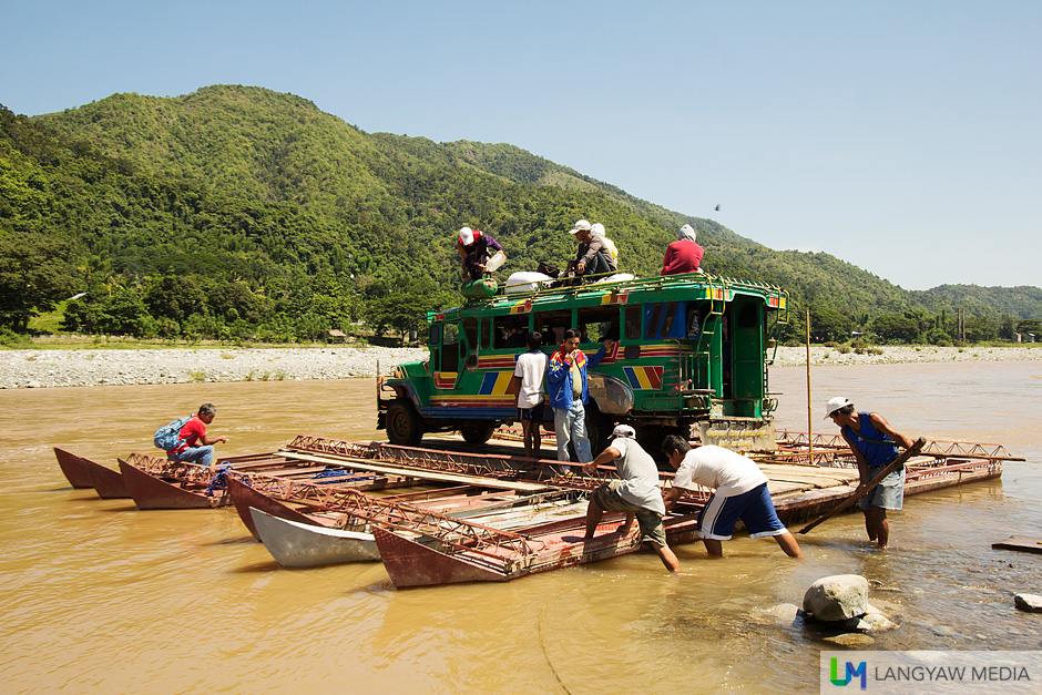 A passenger jeepney going back to Bangued rides the metal raft