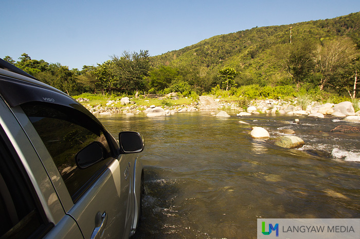 Our offroad vehicle trying to cross the rocky but shallow river