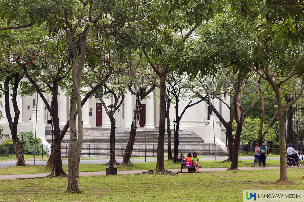 Under the shade of trees people spend lazy afternoons