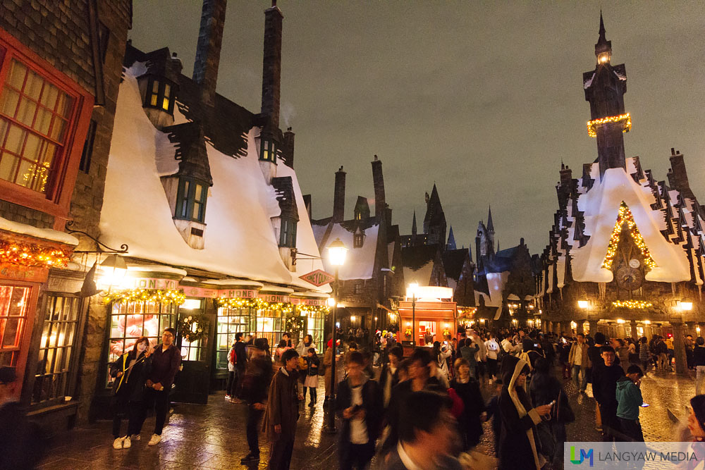Hogsmeade Village is aglow with warm lights and festive decors